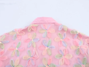 Close-up of 3D colorful floral embroidery and sequins on the back of the pink shirt