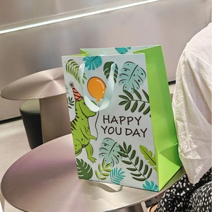 Large green dinosaur gift bag with Happy You Day print and light blue ribbon handles