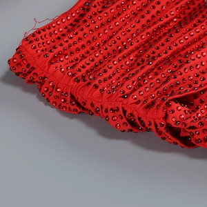Detailed macro view of red rhinestones on flexible fabric of a fitted evening gown