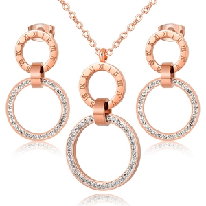 Detailed view of rose gold roman numeral necklace and stud earrings set with rhinestones