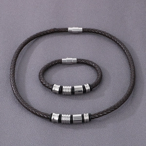 Detail of dark brown braided leather cord and polished silver magnetic clasp closure