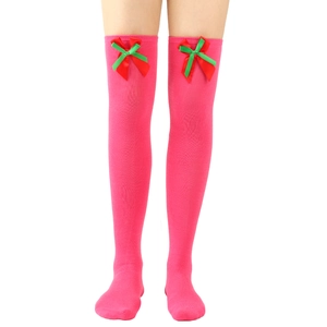 Detail of pink over-the-knee socks with red and green Christmas bow decorations