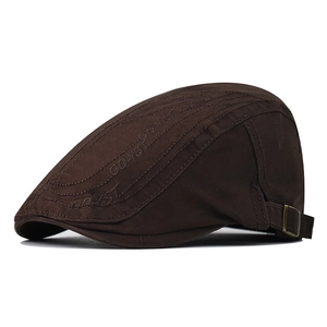 Close-up of brown cotton beret featuring vintage metal buckle and GDYST embroidery