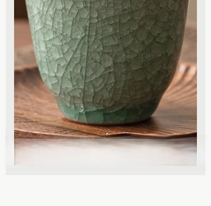 Macro view of Ru kiln ceramic teacup with celadon ice-crack glaze and wood tray
