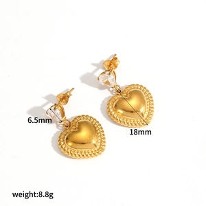Macro detail of gold double heart earrings with 6.5mm zircon and 18mm textured pendant