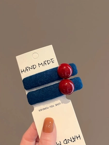 Close-up of blue and red velvet hair clips with resin beads and handmade card