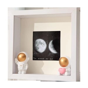 3D shadow box frame with astronauts and lunar phase backdrop titled The moment we met