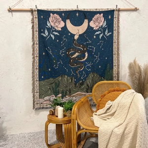 Detail of woven tapestry with snake moon and rose patterns plus bohemian tassels