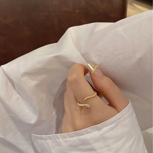 Adjustable golden S925 sterling silver snake ring with textured scale design on a finger