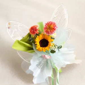 Gros plan d'un bouquet de fleurs avec ailes de papillon en acrylique et papier vert