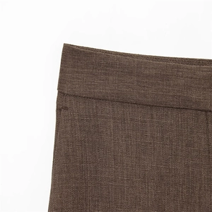 Détail macro de la couture sur le tissu marron uni d'un blazer à texture lisse