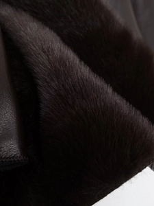 Close-up of the premium faux fur lining and smooth leather texture of the reversible jacket
