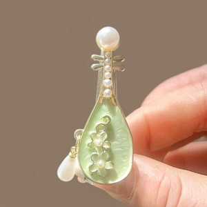 Détail de la pince à cheveux Pipa vintage avec émail vert, bords dorés et perles