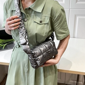 Detail of silver quilted crossbody bag with metallic finish and adjustable shoulder strap