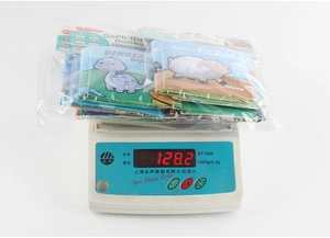Weight measurement of soft baby cloth books set showing 128.2g on digital scale