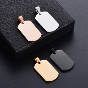 Macro view of four polished stainless steel military dog tags in silver, gold, and black