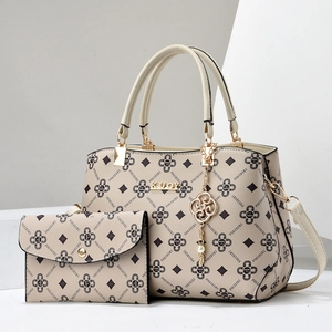 Macro detail of beige printed tote with matching clutch and gold-tone metal hardware