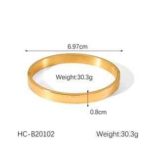 Detail view of gold Roman numeral bangle with dimensions 6.97cm diameter and 0.8cm width