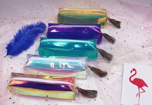 Close-up of laser holographic pencil cases with colorful tassels and metallic finish