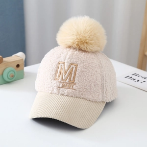 Detail of baby teddy fleece baseball cap with M embroidery and faux fur pom pom