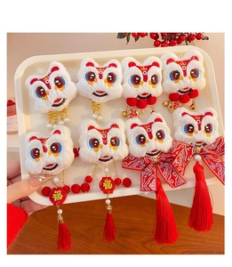 Detail of plush Chinese lion hair clips with red tassels and festive Fu characters