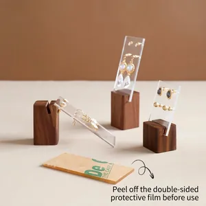 Acrylic jewelry display stand with walnut wood base for earrings and studs in studio setting