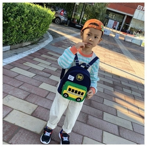 Outdoor shot of the kids school bag with a yellow bus pocket on a dark blue backpack