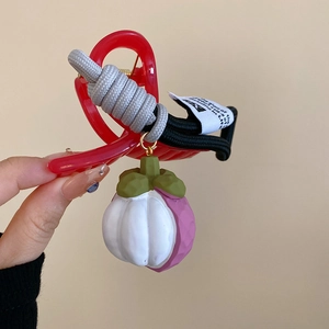 Detailed close-up of a red translucent hair claw clip with a cute mangosteen pendant
