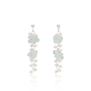 Detailed view of silver stud earrings with light green matte flowers and crystal tassels