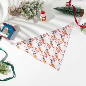 Flat lay of festive Christmas pet bandana with Santa and reindeer patterns and holiday decor