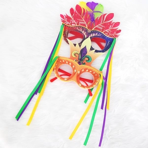 Carnival party glasses with vibrant feathers and hanging colorful fringe decorations
