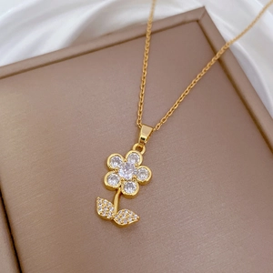 Close-up of golden flower pendant with sparkling white cubic zirconia and stem detail