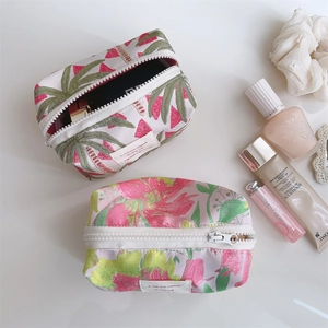 Detail of rose pink jacquard makeup bags with tropical leaf and floral patterns