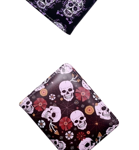Detail of gothic spider web and skull print patterns on bifold PU leather wallet