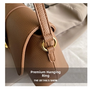 Close-up of golden ring buckle and stitching on brown litchi pattern leather bag