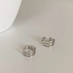 Macro shot of silver triple-layered metal ear cuffs with polished reflective finish