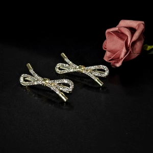 Elegant gold bow hair clips set with sparkling rhinestones on a black background