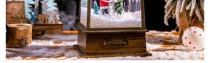 Gros plan d'une boule à neige de Noël style bois vintage avec plaque Merry Christmas