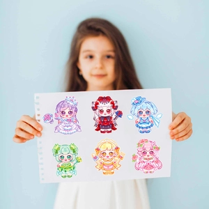 Close-up of a hand holding six colorful cartoon doll stickers for DIY scrapbooking decor