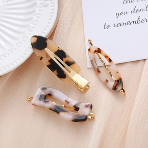 Detailed view of 3-piece acetate hair clips with amber tortoise pattern and gold plating