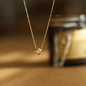 Macro shot of 18K gold plated hexagon pendant necklace with a brilliant round zircon stone