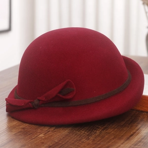 Detailed view of the wool felt bowler hat in burgundy with dark ribbon and bow accent