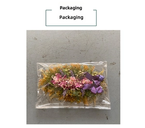 Detail view of purple artificial hydrangea flowers and satin bow in transparent packaging