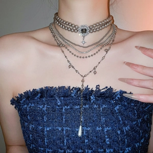 Close-up of elegant layered grey pearl choker with rhinestone star and Y-shape drop pendant