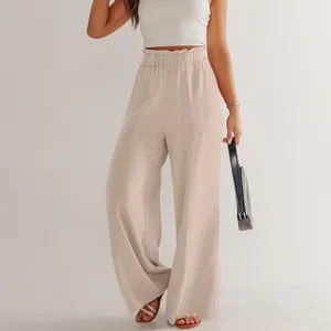 Dettaglio dei pantaloni in lino beige con vita paperbag elastica e trama del tessuto