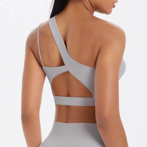 Detailed back view of light gray yoga set with asymmetric shoulder strap and cutout design