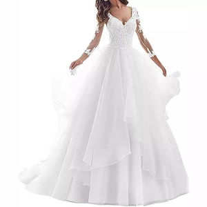 Detail of elegant lace patchwork and sheer long sleeves on a deep V-neck white bridal gown