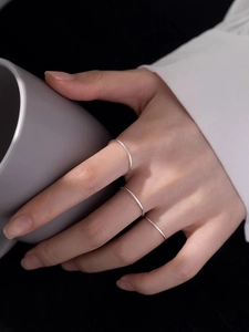 Nahaufnahme von drei minimalistischen silbernen Edelstahl-Stapelringen an einer Hand