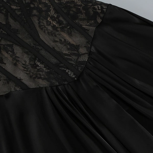 Detailed close-up of floral lace corset and satin pleated fabric on a black evening gown