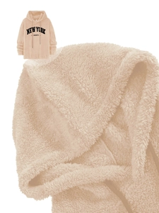 Close-up of beige fleece hoodie featuring black New York embroidered lettering and soft texture